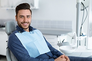 Man in dental chair smiling after dental bonding in Palm Bay, FL