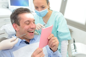 Dentist in Palm Bay showing patient dental crown in mirror