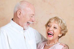 Smiling senior man and woman after denture tooth replacement