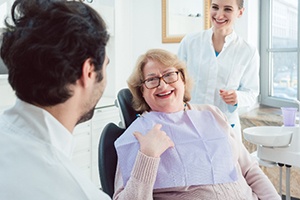 Mature woman smiling at dentist during dentures consultation