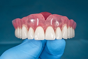 Close-up of gloved hand holding dentures