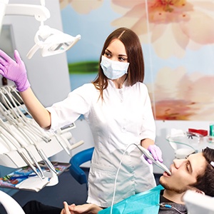 Man and dentist looking at computer monitor before tooth extraction