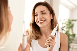 woman holding an electric toothbrush