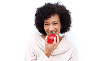 woman biting into a red apple