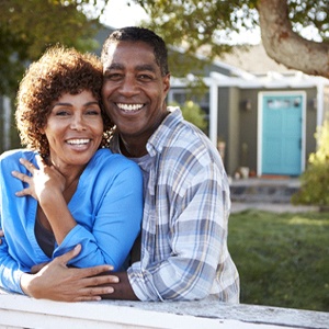 couple with implant dentures in Palm Bay standing in their front yard