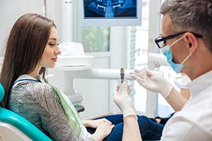 implant dentist in Palm Bay showing a dental implant to a patient