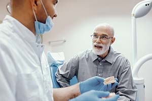 senior man asking his dentist about dental implants