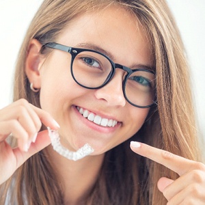 Smiling woman points to ClearCorrect tray in Palm Bay