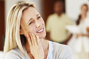 Distraught woman holding cheek before tooth extraction