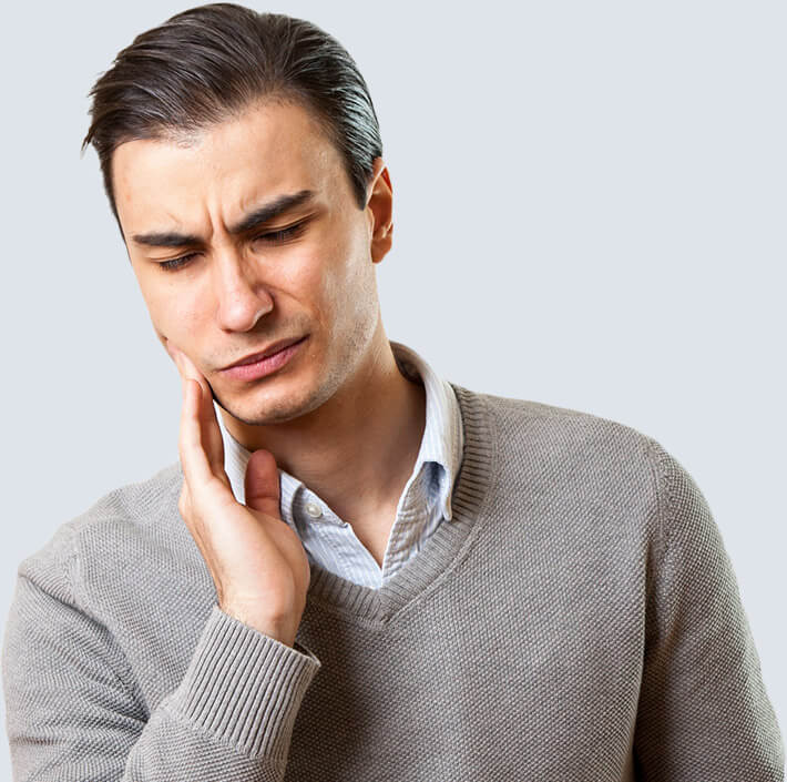 Man holding cheek with pained expression before emergency dentistry