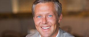 Gentleman in suit smiling after replacing missing teeth with dental implants