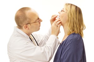 Dentist checking fit of woman’s occlusal splint