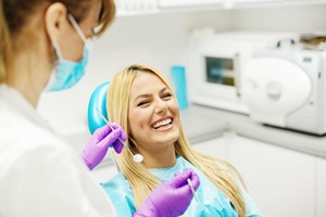 Laughing woman in dental chair for occlusal splint treatment