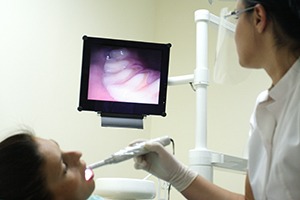 dentist looking at photos of patient's mouth