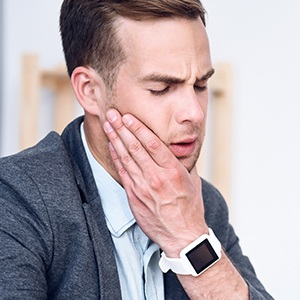 Man holding jaw before T M J therapy