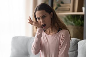 Woman in pink shirt suffering from jaw pain