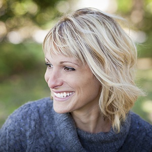 Smiling lady looking off to the distance after porcelain veneer treatment