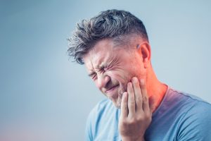 person suffering from tooth pain